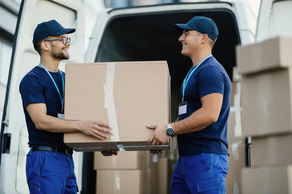 Rapid Packers and Movers Surat movers carrying a sealed carton to the truck in Surat
