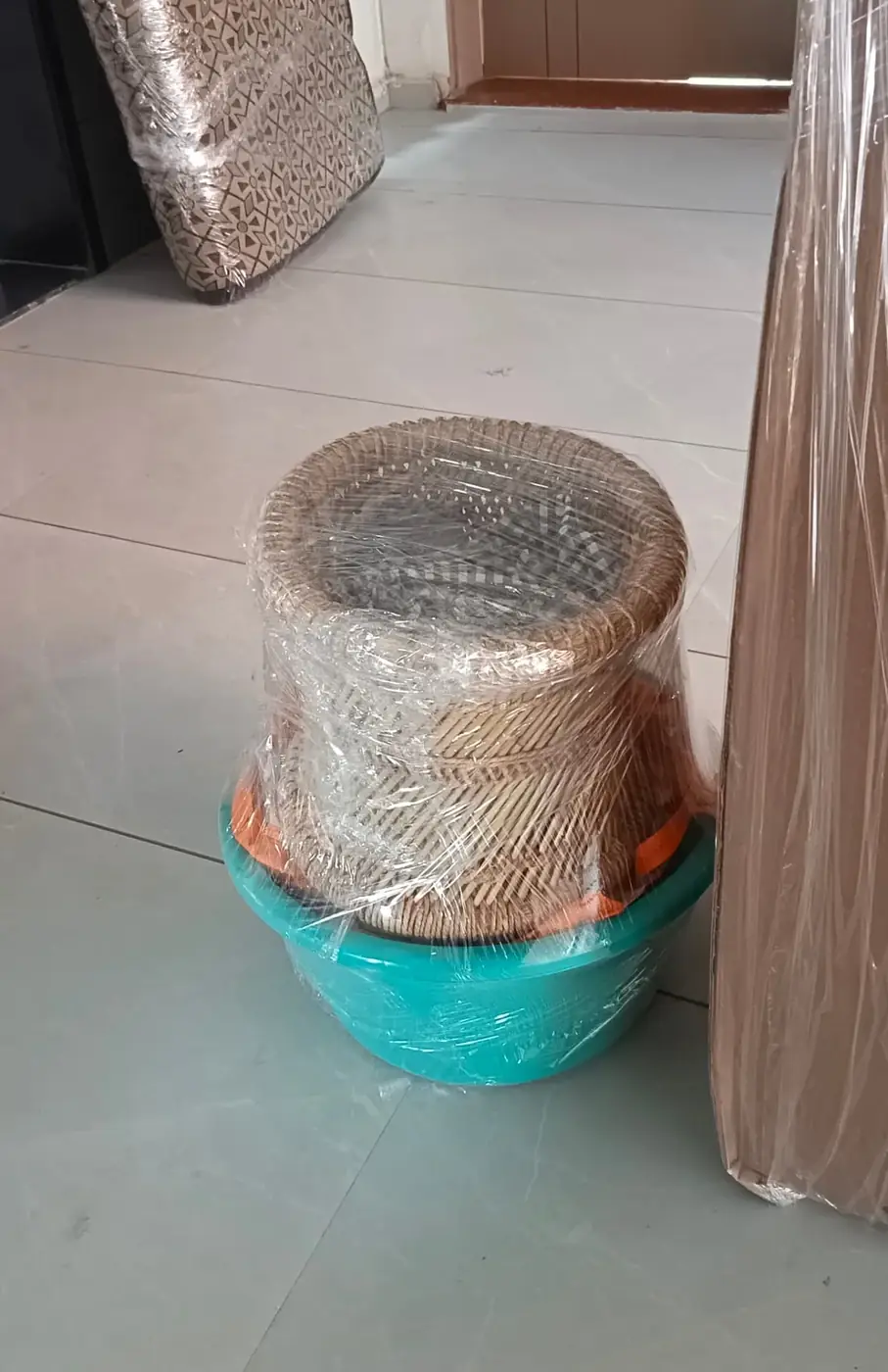 Household items wrapped in stretch film before loading in Surat